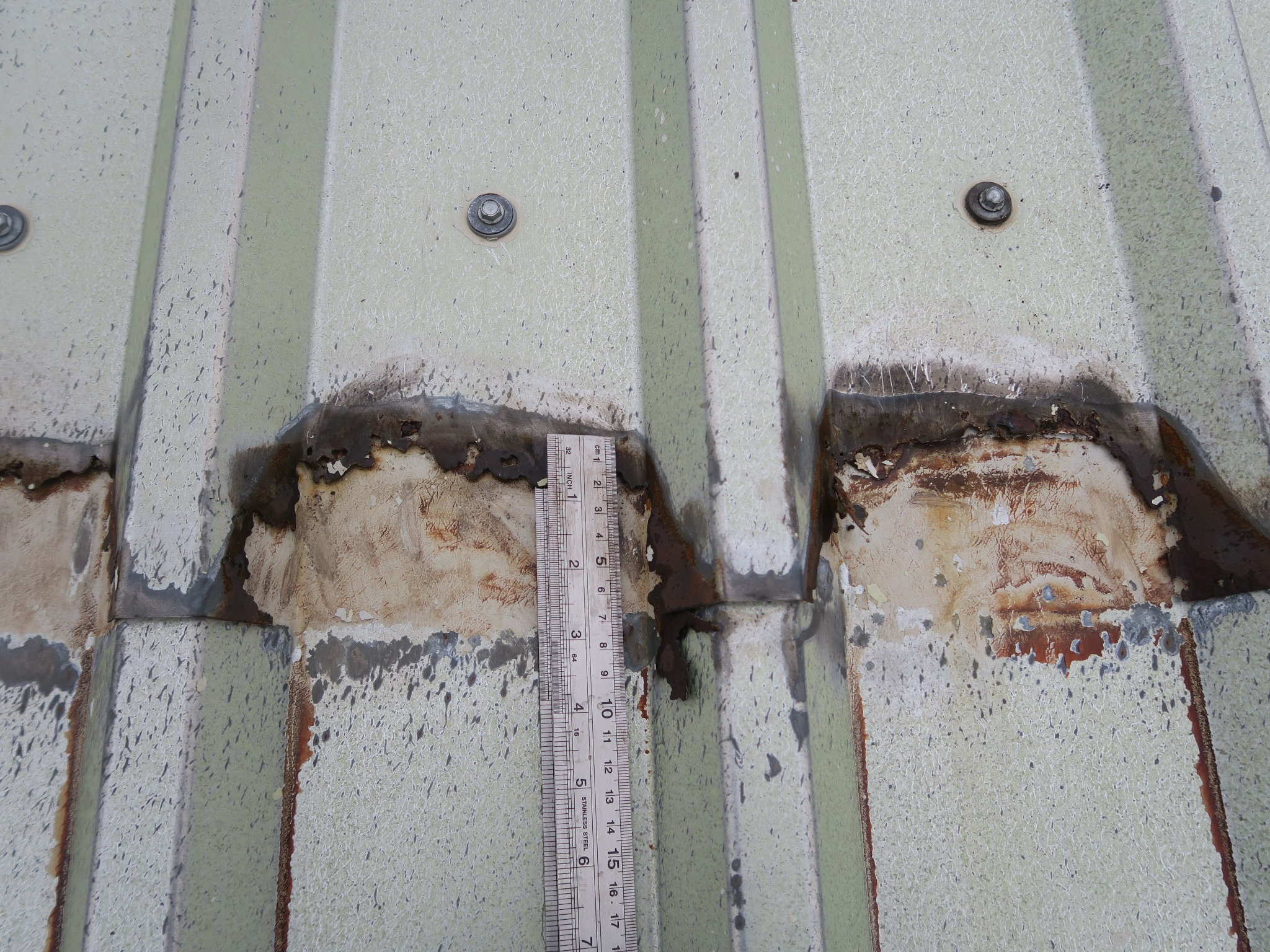 Image showing presence of a weatherproofing strip between tow overlapping roof sheets with extensive corrosion