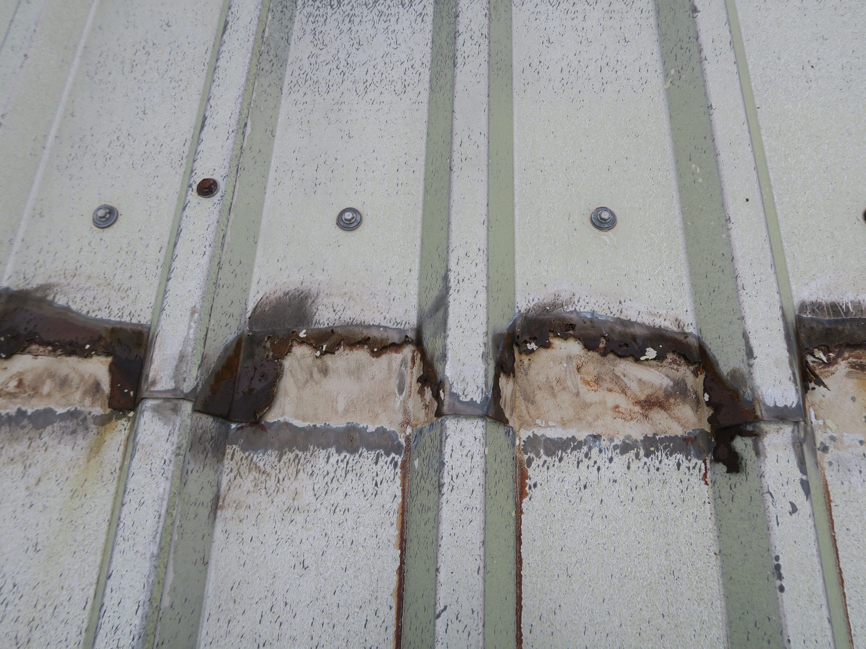 Image showing loss of steel roof sheet at the mid-lap joint after pressure washing