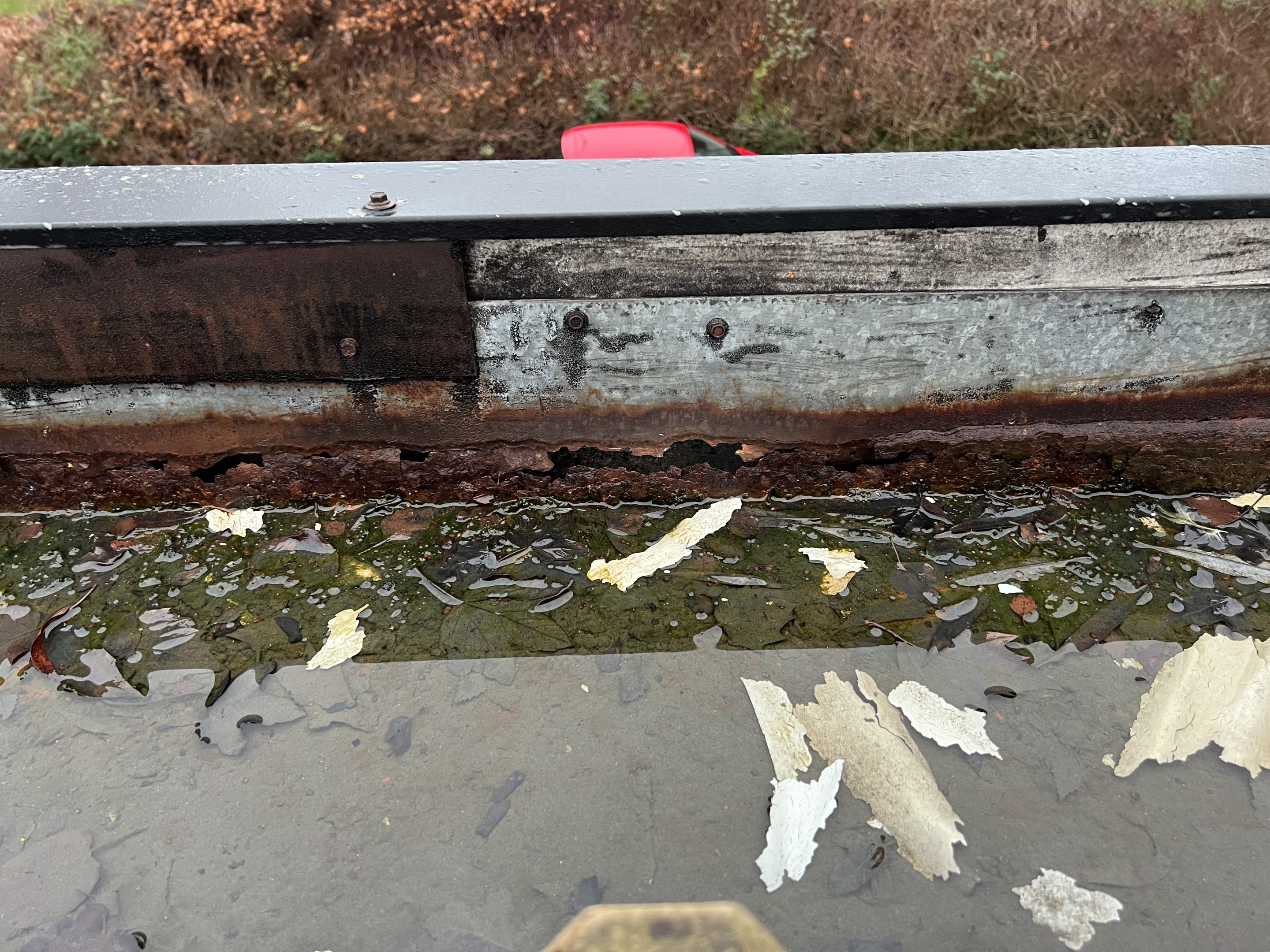 image showing a steel gutter with severe corrosion and loss of substrate