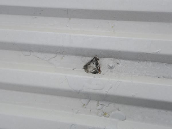 image showing a hole in a newly coated steel roof - proof of not following the repair specification.