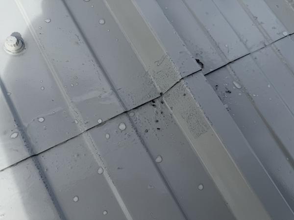 Image of low film thickness on a roof coating project where the different coloured primer can be seen to be grinning through