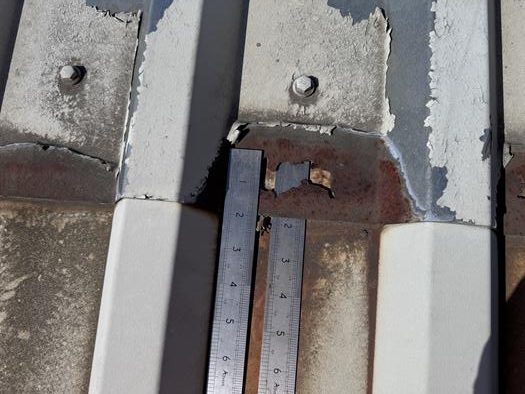 Image showing mid-lap corrosion on a metal roof with loss of the roof sheet due to lack of maintenance