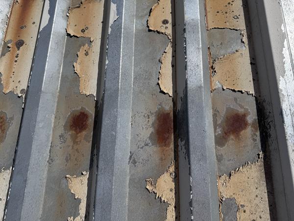 Image showing loss of plastisol on a steel roof, leading to spoty corrosion