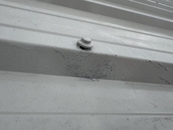 Image showing roof coating applied over an unwinding fixing - a potential source of water ingress