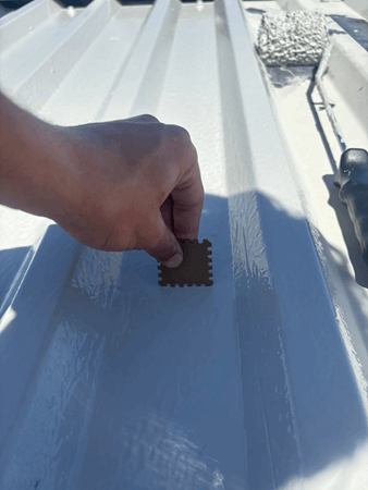 Image showing a wet film comb being used on a Liquasil metal roof coating project